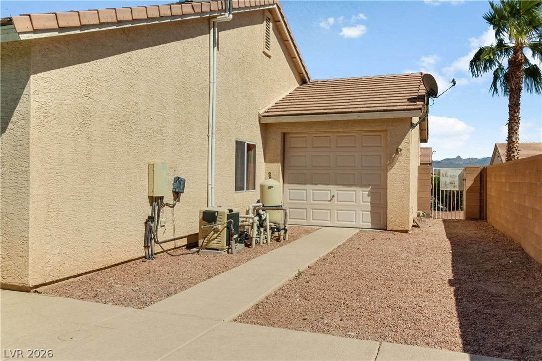 2823 Rippling Springs Street Laughlin, NV 89029 - Photo 67 of 89 View of property exterior featuring stucco siding, a tile roof, the passthrough garage, and a gate