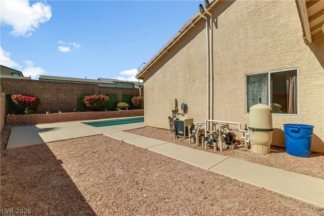 2823 Rippling Springs Street Laughlin, NV 89029 - Photo 68 of 89 View of home's exterior featuring stucco siding, a fenced backyard, a patio area, and an outdoor pool