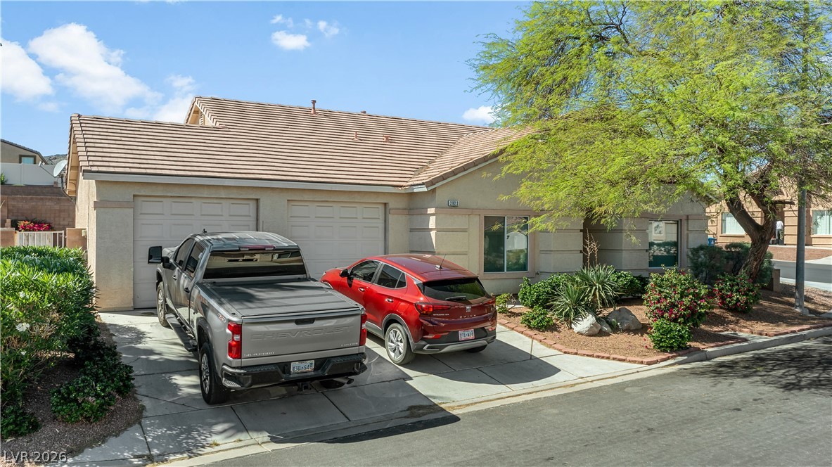 2823 Rippling Springs Street Laughlin, NV 89029 - Photo 74 of 89 View of front facade featuring stucco siding, an attached garage, concrete driveway, and a tile roof