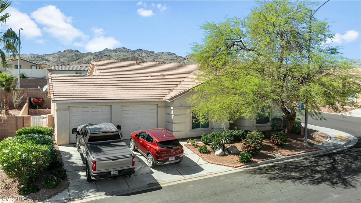 2823 Rippling Springs Street Laughlin, NV 89029 - Photo 75 of 89 View of front of property featuring an attached garage, driveway, stucco siding, a mountain view, and a tile roof