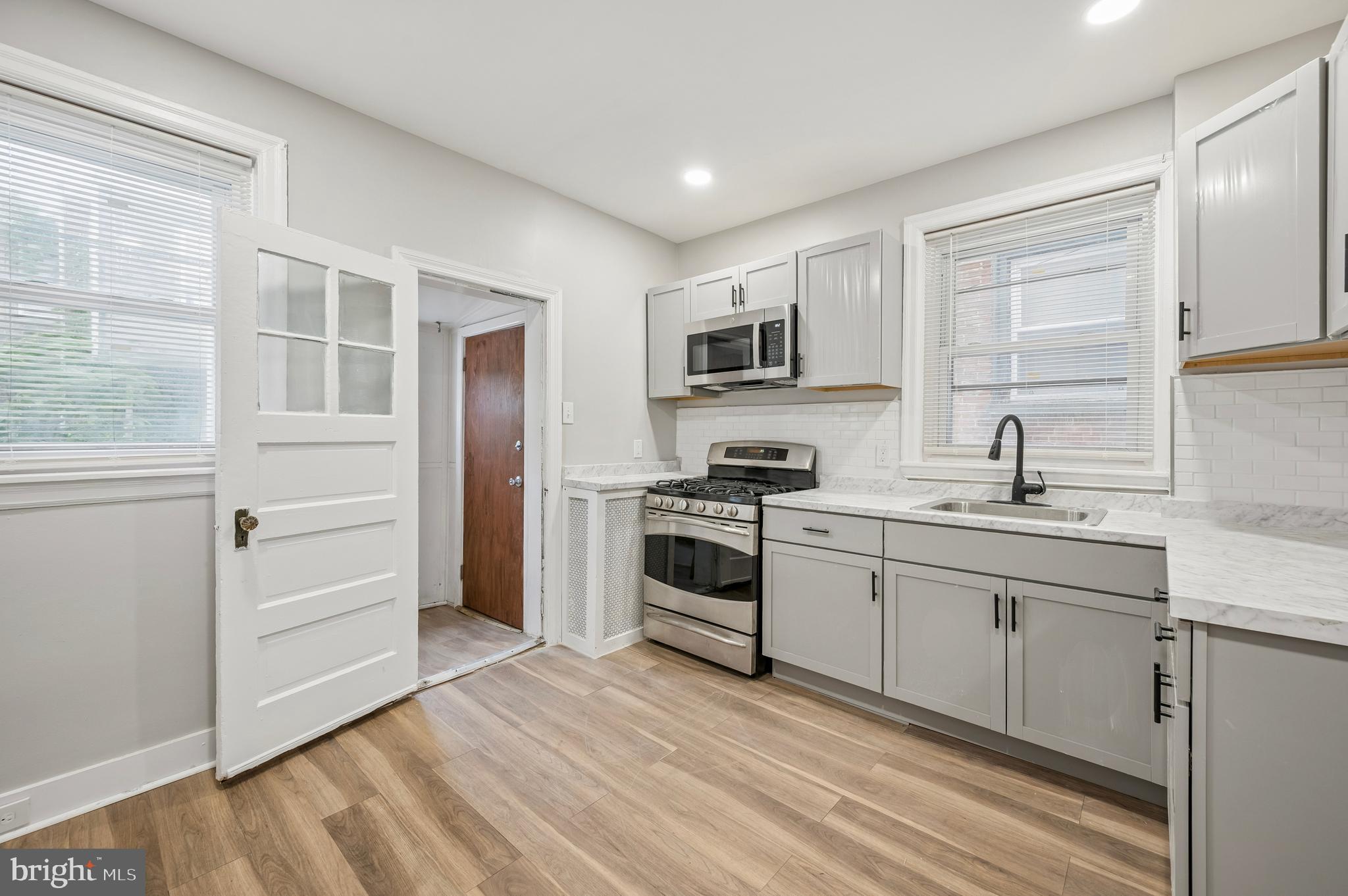 5625 Willows Avenue Philadelphia, PA 19143 - Photo 5 of 15 a kitchen with a sink cabinets stainless steel appliances and a window