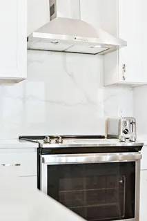 a kitchen with stainless steel appliances granite countertop a refrigerator a stove and white cabinets