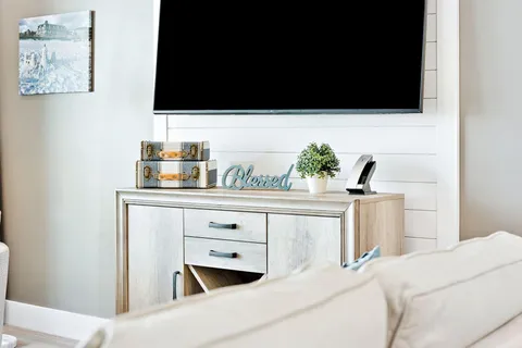 a bedroom with bed tv and a window