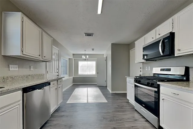 a kitchen with stainless steel appliances granite countertop a stove a microwave and a sink