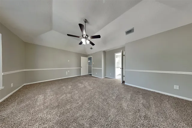 a view of an empty room with a ceiling fan