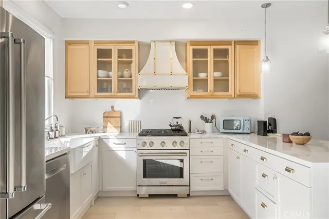 a kitchen with stainless steel appliances granite countertop a stove sink and cabinets