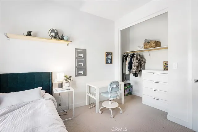 a living room with furniture a flat screen tv and a refrigerator