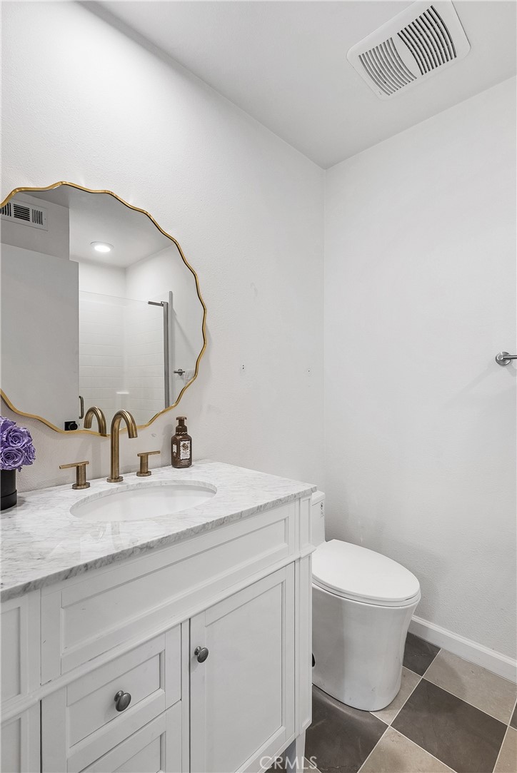 2581 Arvia Street, Unit 3 Los Angeles, CA 90065 - Photo 27 of 52 a bathroom with a granite countertop toilet a sink and mirror
