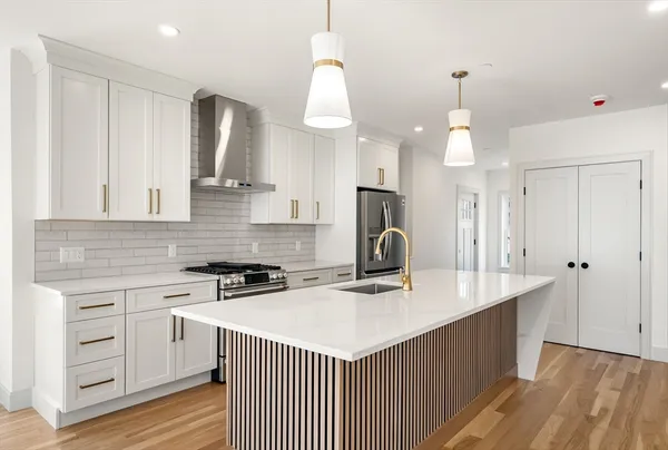 a kitchen with a sink a stove a refrigerator and cabinets