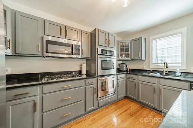 a kitchen with stainless steel appliances granite countertop a sink stove and microwave
