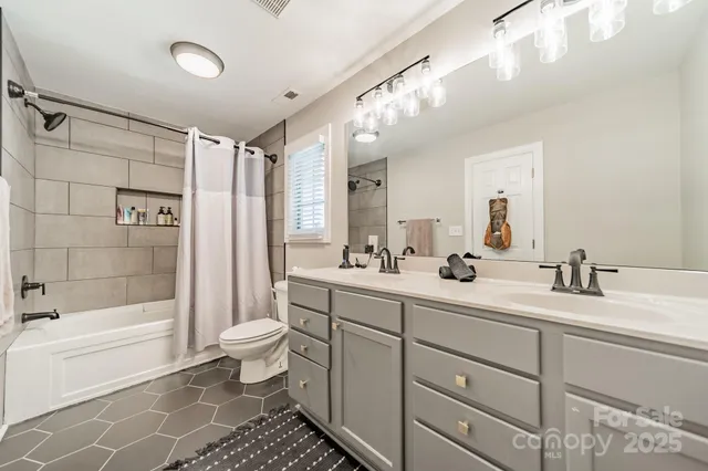 a bathroom with a double vanity sink toilet mirror and bathtub