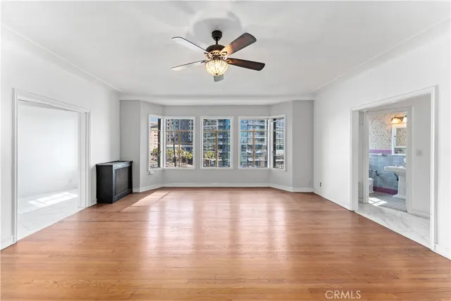 a view of an empty room with a window and wooden floor