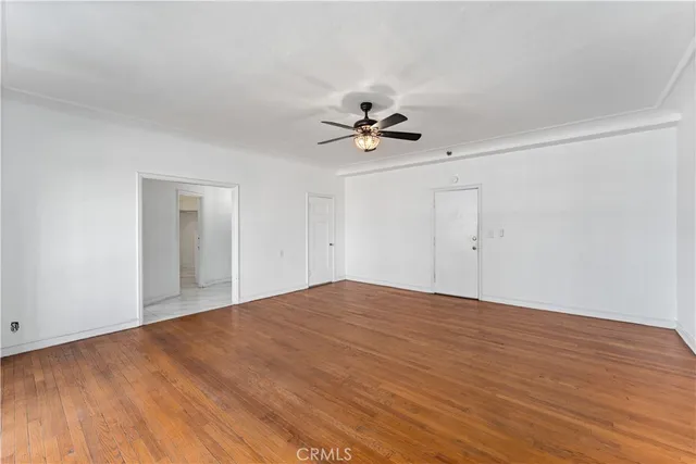 a view of empty room with wooden floor