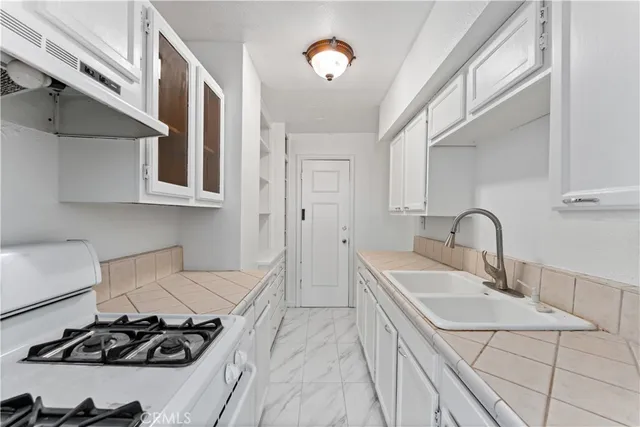 a kitchen with stainless steel appliances granite countertop a sink stove and cabinets