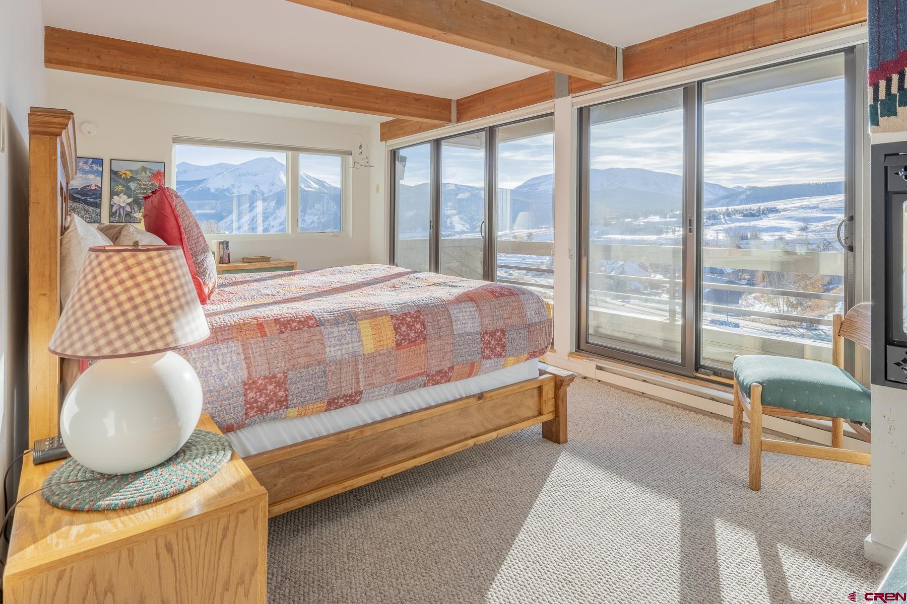 11 Hunter Hill Road, Unit 307 Crested Butte, CO 81225 - Photo 15 of 34 a bedroom with a bed and glass window