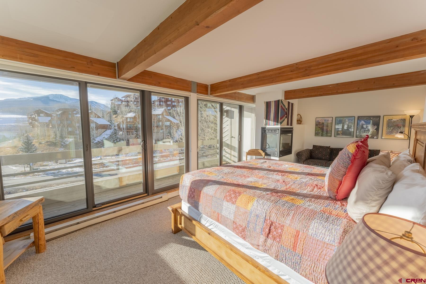 11 Hunter Hill Road, Unit 307 Crested Butte, CO 81225 - Photo 16 of 34 a bed sitting in a bedroom next to a large window