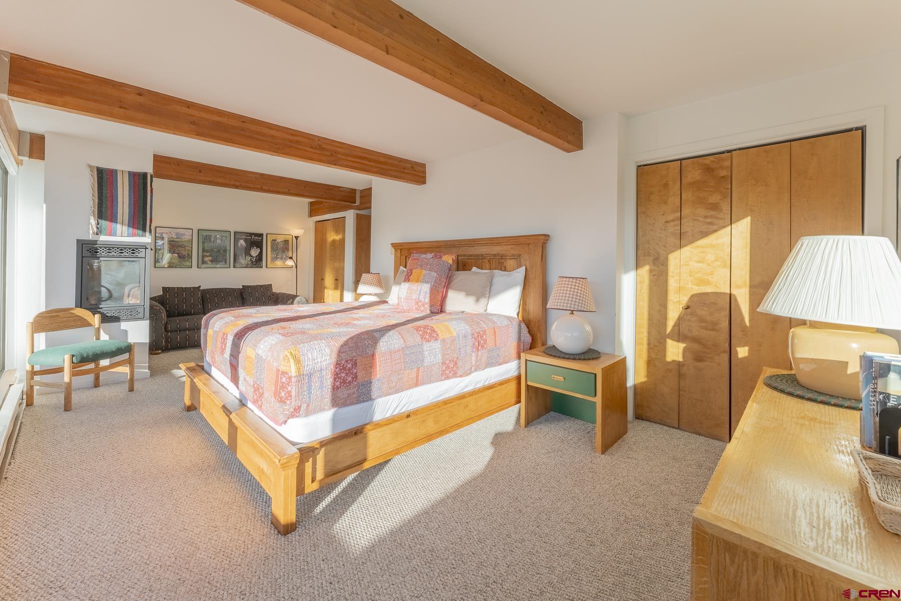 11 Hunter Hill Road, Unit 307 Crested Butte, CO 81225 - Photo 17 of 34 a spacious bedroom with a bed and lamp