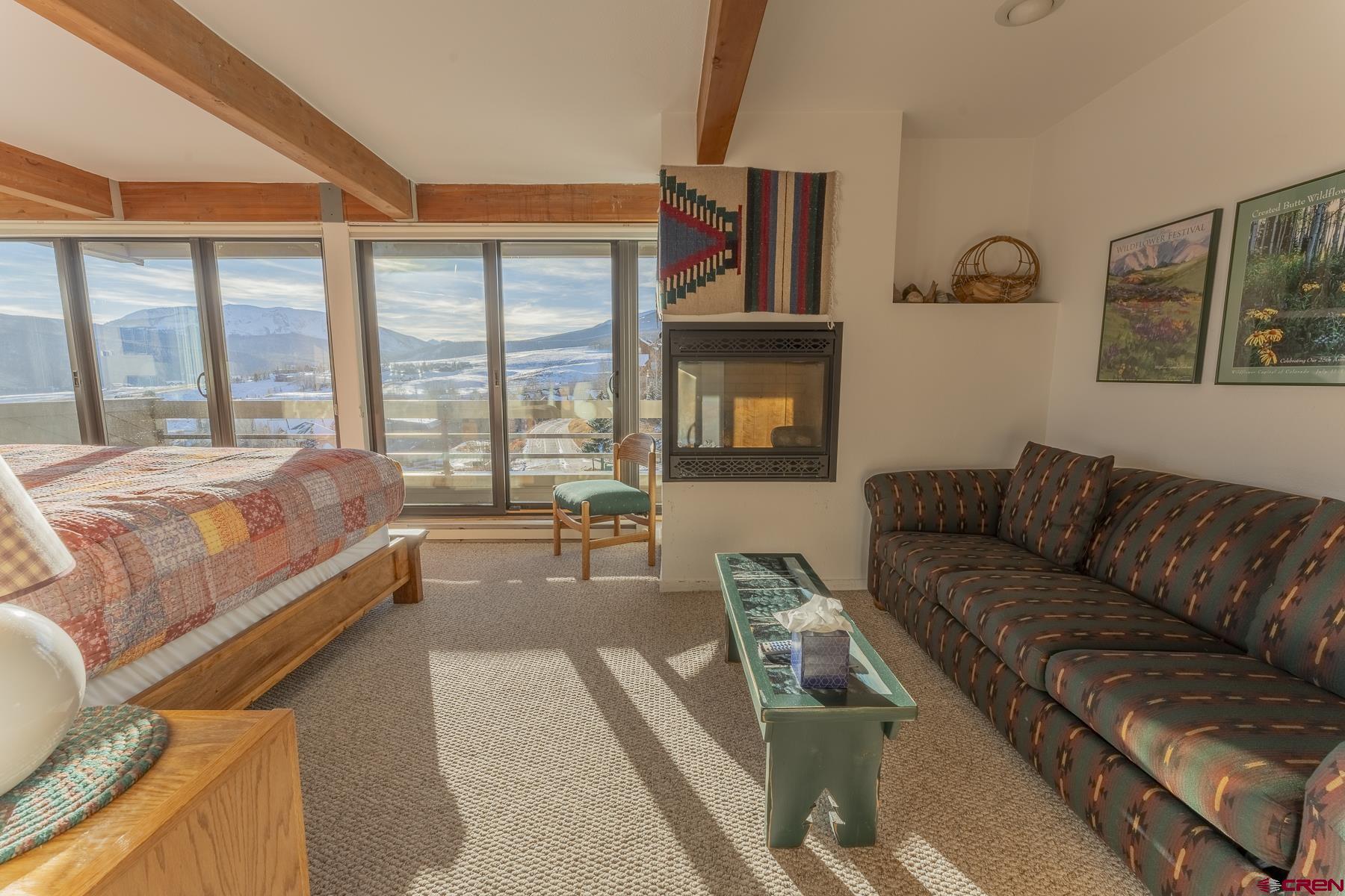 11 Hunter Hill Road, Unit 307 Crested Butte, CO 81225 - Photo 18 of 34 a bedroom with a bed a couch and dresser next to a window