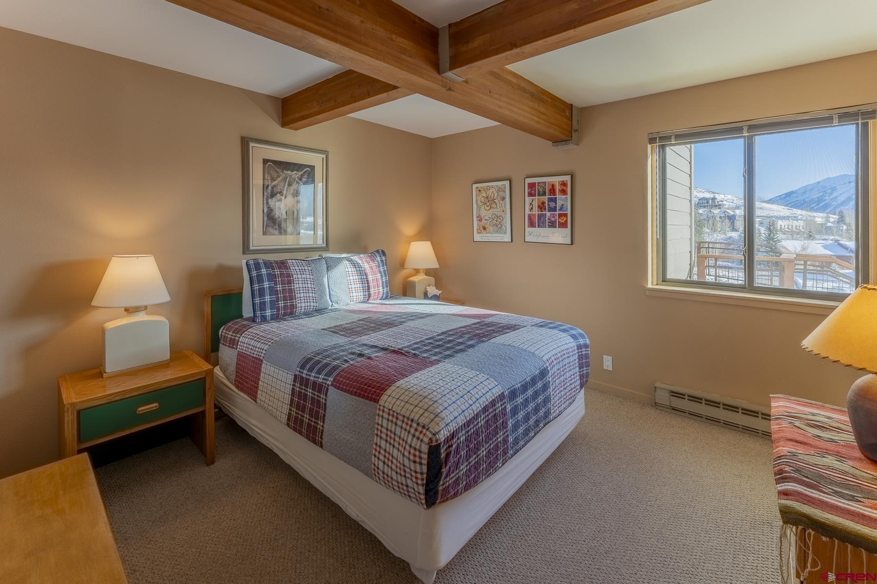 11 Hunter Hill Road, Unit 307 Crested Butte, CO 81225 - Photo 26 of 34 a bedroom with a bed lamp and a window