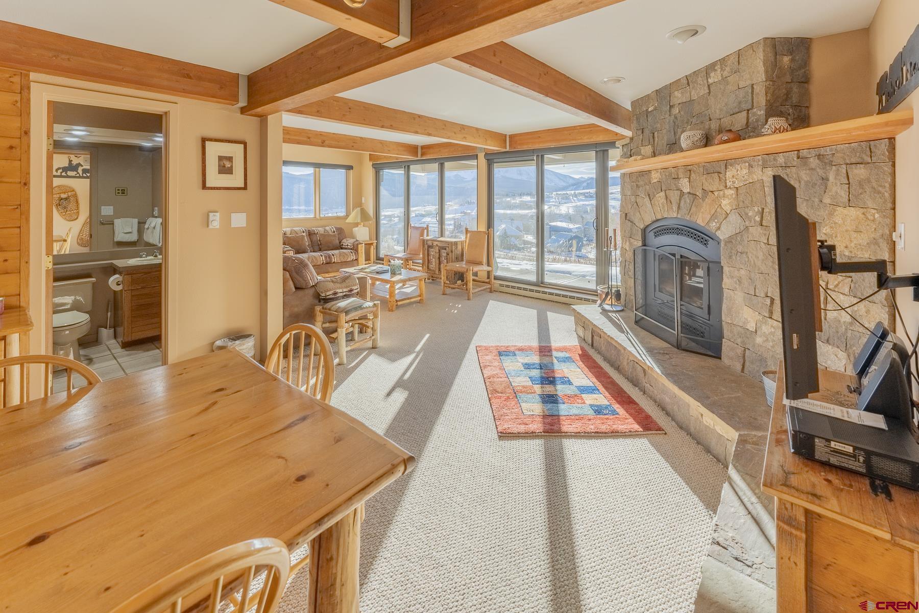 11 Hunter Hill Road, Unit 307 Crested Butte, CO 81225 - Photo 8 of 34 a living room with furniture a fireplace and wooden floor