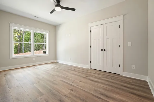 an empty room with wooden floor and mirror