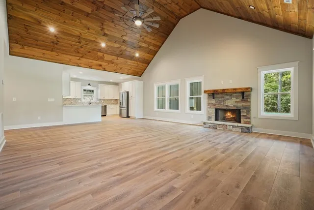 a view of empty room with a fireplace and wooden floor
