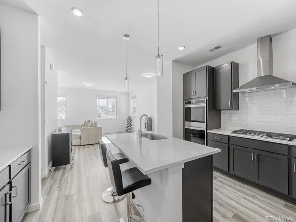 a kitchen with stainless steel appliances kitchen island granite countertop a sink refrigerator and cabinets