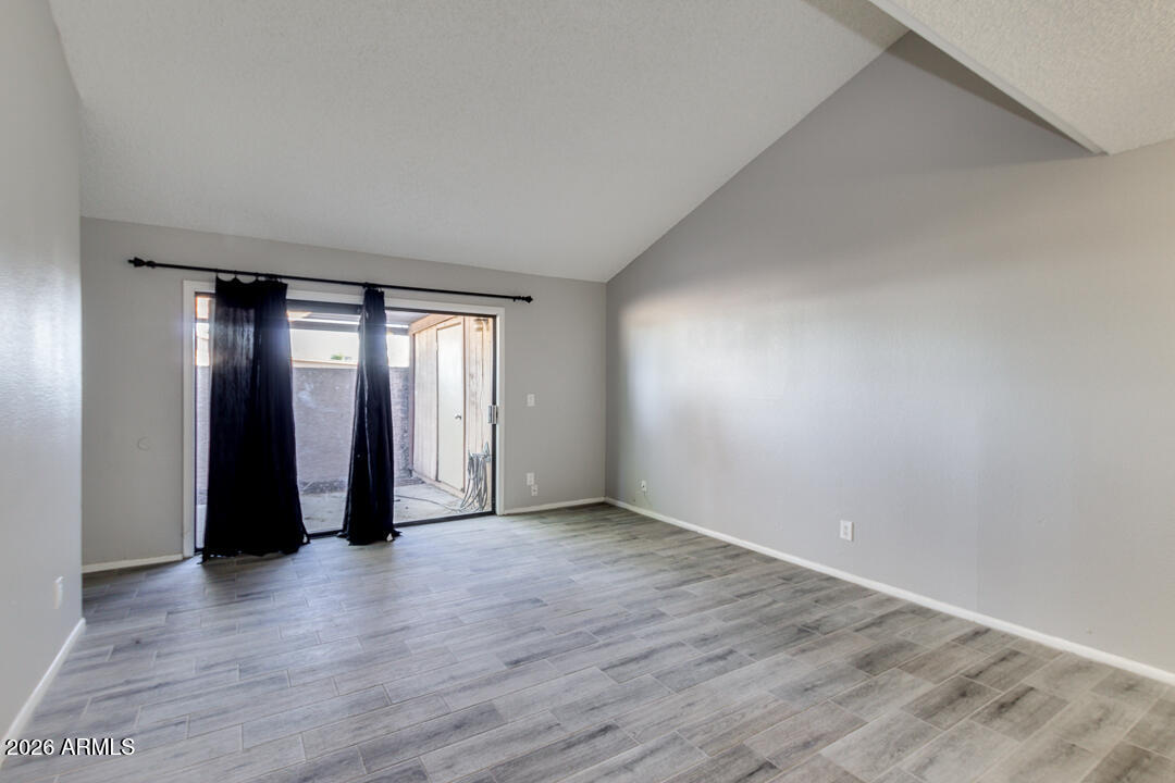 2149 East 10th Street, Unit 3 Tempe, AZ 85281 - Photo 2 of 14 a view of an empty room with wooden floor and a window
