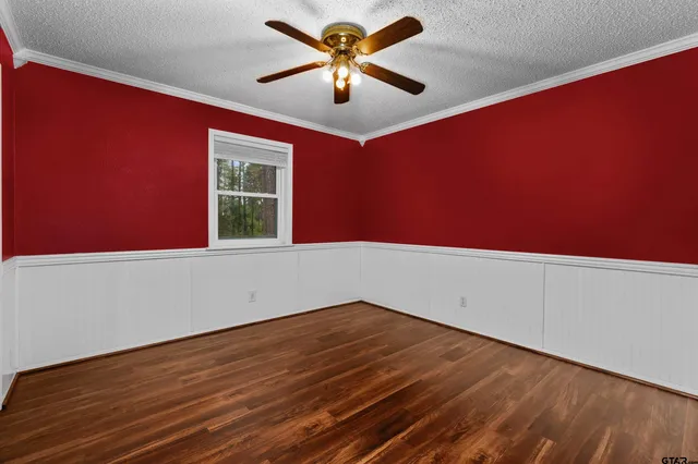 a view of empty room with wooden floor