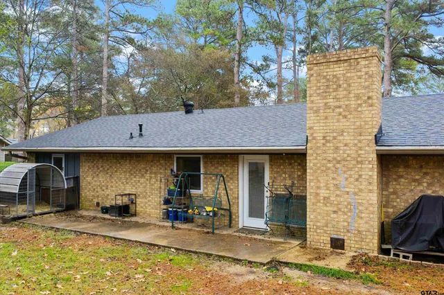 a front view of a house with a yard tree and outdoor seating