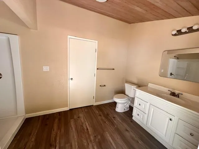 a bathroom with a granite countertop toilet and a sink