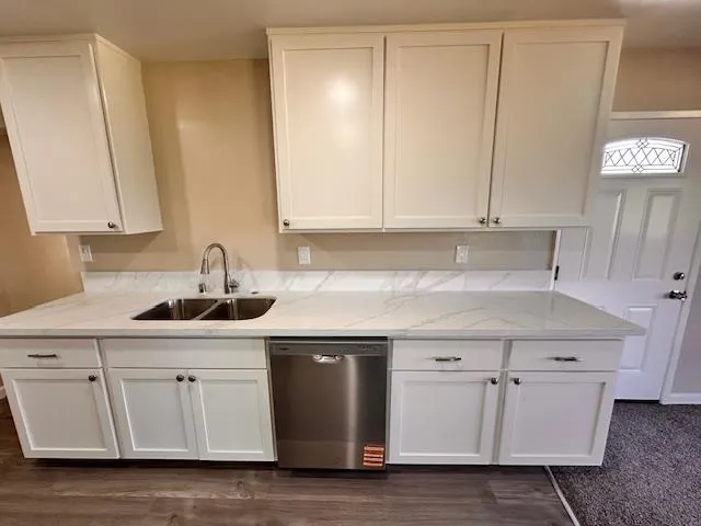 a kitchen with white cabinets appliances and sink