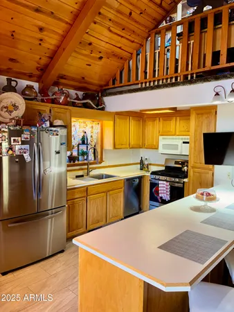 a kitchen with stainless steel appliances granite countertop a sink a stove and a refrigerator