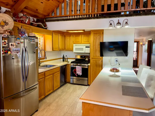 a kitchen with stainless steel appliances kitchen island granite countertop a refrigerator and a stove top oven