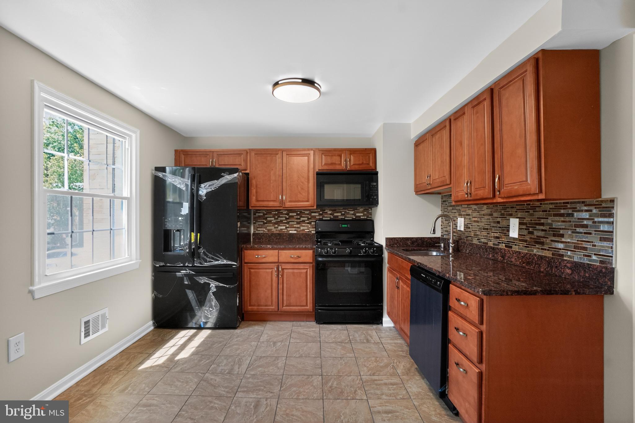 1232 Palmer Road, Unit 111 Fort Washington, MD 20744 - Photo 9 of 45 a kitchen with stainless steel appliances granite countertop a stove top oven a sink dishwasher a refrigerator and cabinets with wooden floor