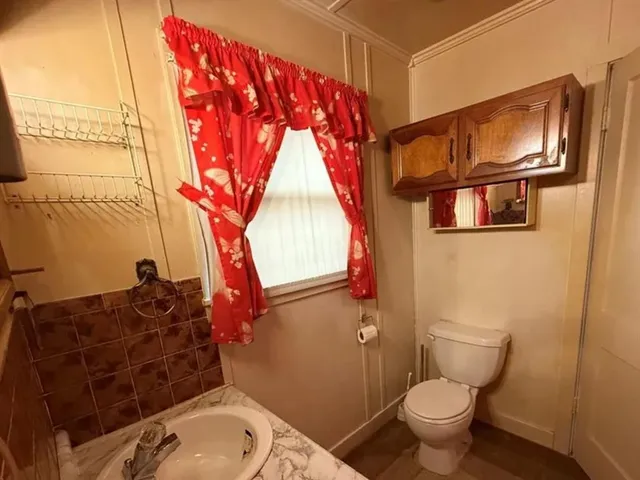 a bathroom with a toilet sink and mirror