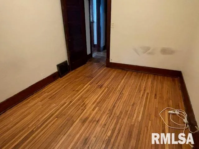 a view of a room with wooden floor and door