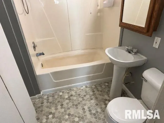 a bathroom with a sink a toilet a mirror and shower