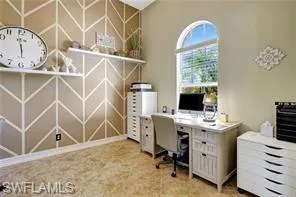 a view of a workspace with furniture and a window