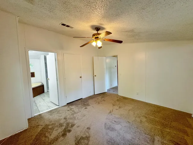 a bedroom with a bed and a chandelier fan