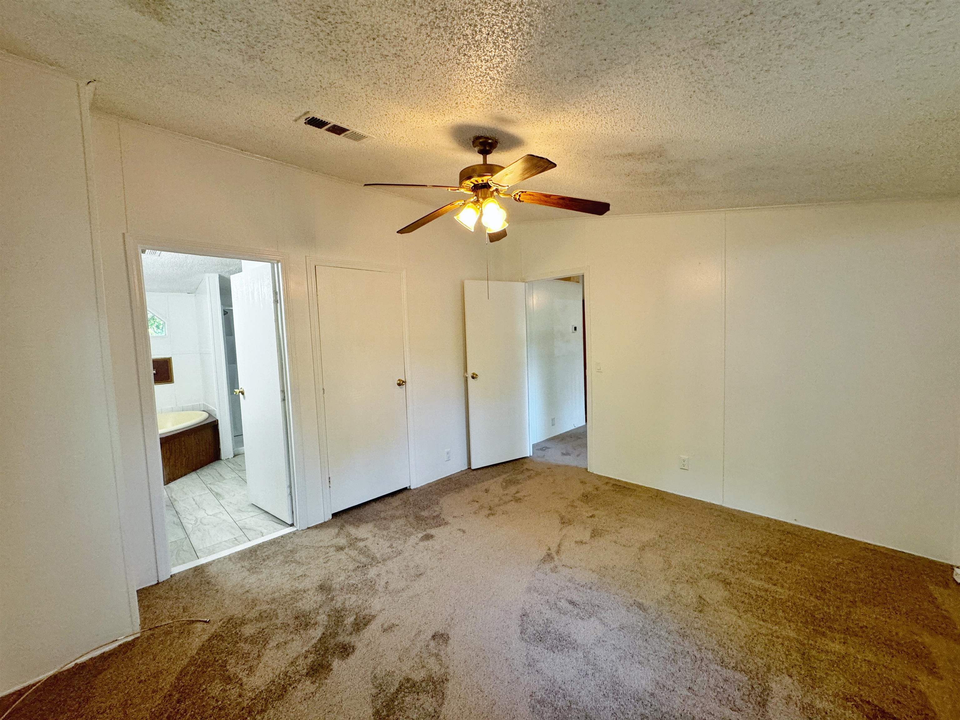 5872 Pine Creek Drive St. Augustine, FL 32092 - Photo 11 of 26 a bedroom with a bed and a chandelier fan