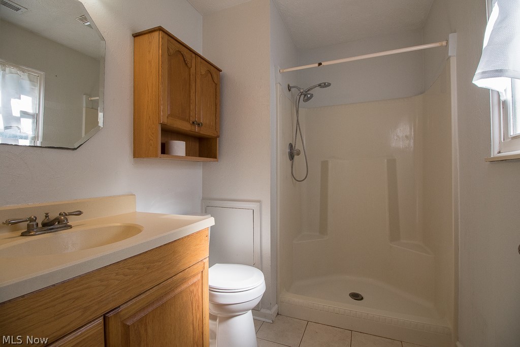 2744 Haines Road Madison, OH 44057 - Photo 21 of 26 Bathroom featuring vanity, walk in shower, tile flooring, and toilet