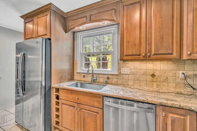 a kitchen with stainless steel appliances granite countertop a refrigerator and a sink