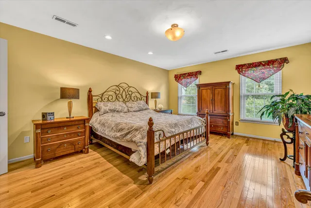 a bedroom with a bed and wooden floor