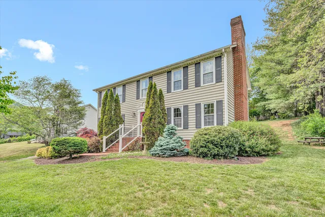 a view of a house with backyard and sitting area