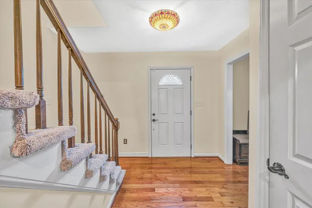 a view of a livingroom with wooden floor and stairs