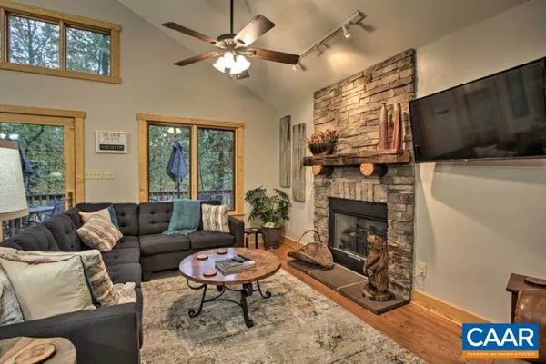 a living room with furniture a fireplace and a flat screen tv