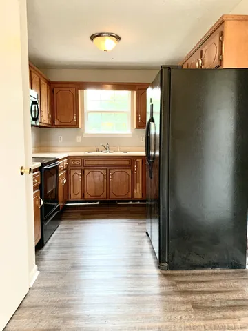 a large kitchen with stainless steel appliances granite countertop a stove a sink and a refrigerator