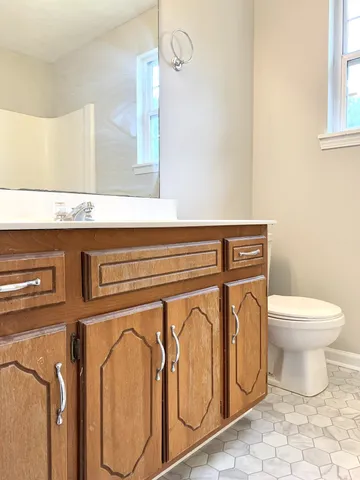 a bathroom with a granite countertop sink and a toilet