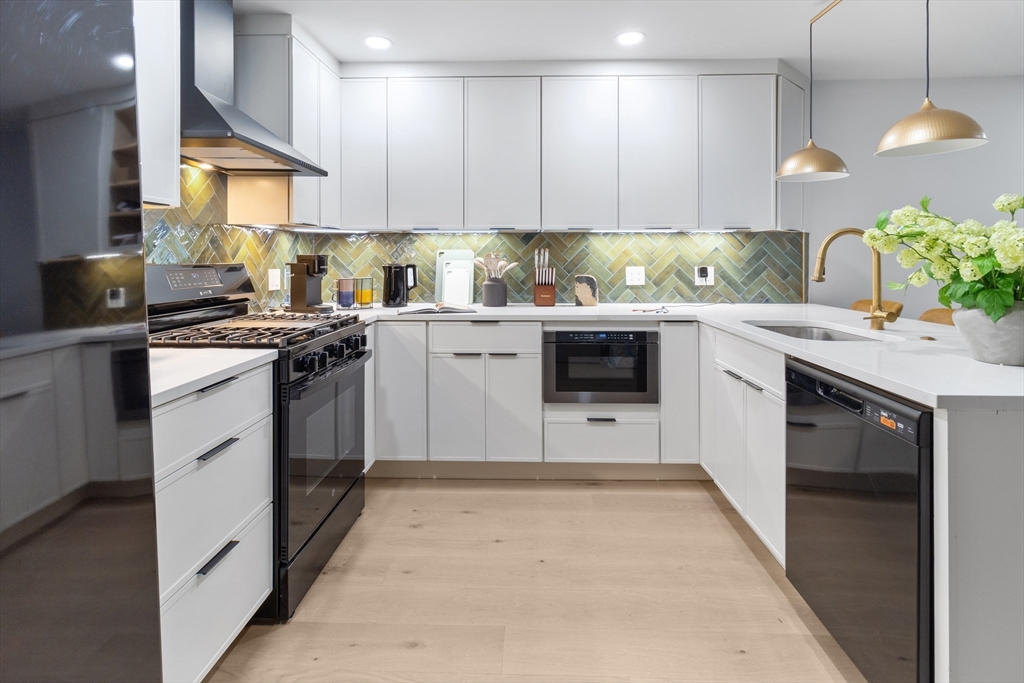 4 Snelling Place, Unit 4 Boston, MA 02113 - Photo 4 of 15 a kitchen with stainless steel appliances granite countertop a stove sink and cabinets
